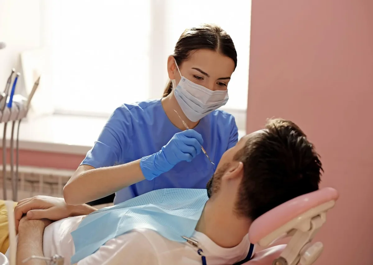 Dental professional examining a patient’s teeth while discussing dental bonding costs and treatment options.