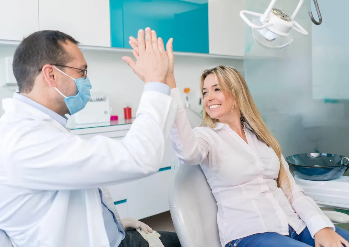 Patient celebrating with her dentist after reviewing her digital smile design and treatment results.